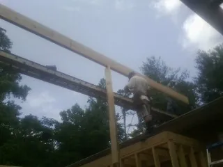 Carpenter setting a ridge beam over a new addition frame — Ice Dam Removal by Roofing Brothers in Lomira