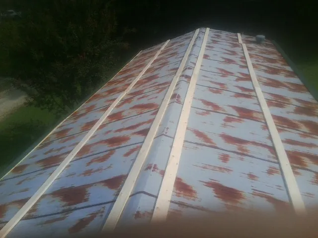 Rusted metal roof panels with new wood purlins before replacement — Storm Damage Roof Repair in Lomira by Roofing Brothers