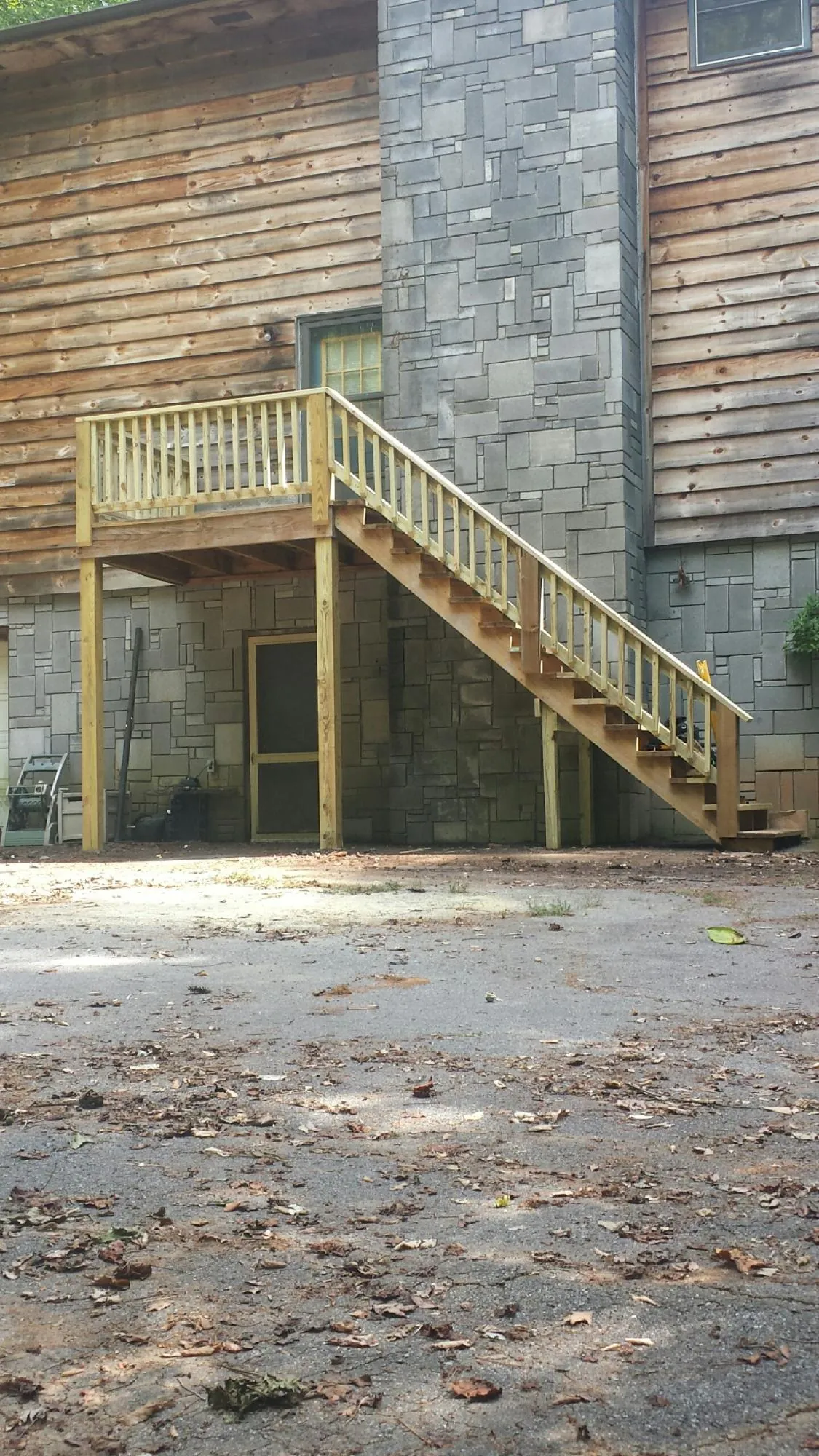 New pressure treated deck and stair landing on a log home in Lomira